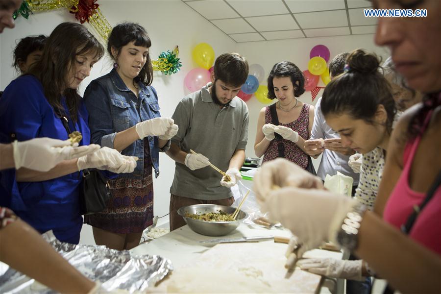 Argentine grant holders who studied in China take part in the preparation of jiaozi (traditional Chinese dumplings) during a meeting at House of the Chinese Culture in Buenos Aires, capital of Argentina, on Feb. 27, 2016. (Photo: Xinhua/Martin Zabala) 