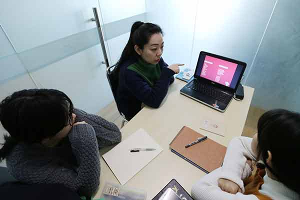 Two students take an English class at Menglish Academy, an education company that provides tailored coaching services to overseas study applicants in Beijing. (Photo: China Daily/Wang Zhuangfei)