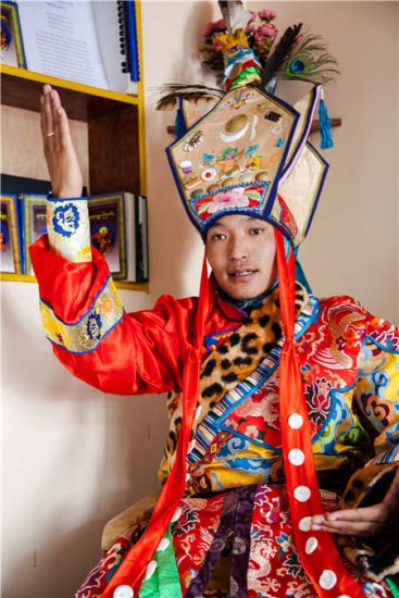 Sithar Dorje was on act while suited with King Gesar dresses ready for his performance in Lhasa. (Photo by Kalzang Gyatso/China Daily)