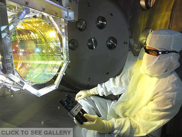 A technician inspects one of the US laboratory's core optics (mirrors) by illuminating its surface at different angles.Caltech / MIT / Ligo LAB