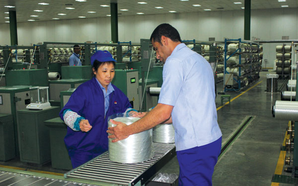 Jushi Egypt workers on a production line in the China-Egypt Suez Economic and Trade Cooperation Zone. It has an annual output capacity of 80,000 metric tons. (Photo provided to China Daily)
