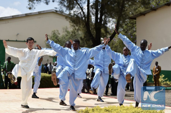 A teacher from China's Donghua University plays Tai Chi with students of Moi University during the opening ceremony of Confucius Institute at Moi University in Eldoret town, Kenya, March 30, 2015. (Photo: Xinhua/Sun Ruibo)