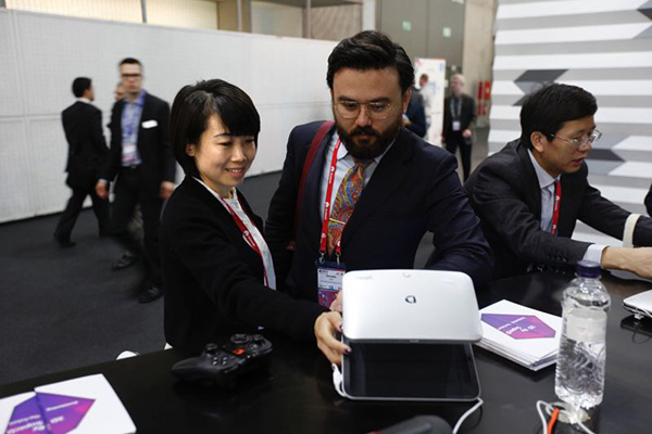 A member of SuperD Co Ltd staff demonstrates the company's glass-free 3D device to a visitor to the Mobile World Congress, Feb 25, 2016. (Photo provided to chinadaily.com.cn