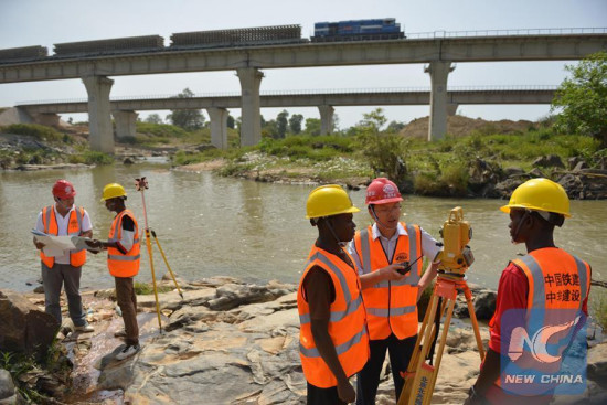 Chinese and local employees work at the construction site of a rail project linking Nigeria's capital city Abuja and its northwestern state of Kaduna, Nov. 25, 2014. The China Railway Construction Corporation carries out the work on the country's first standard gauge railway line. (Xinhua File Photo/Cheng Guangming)
