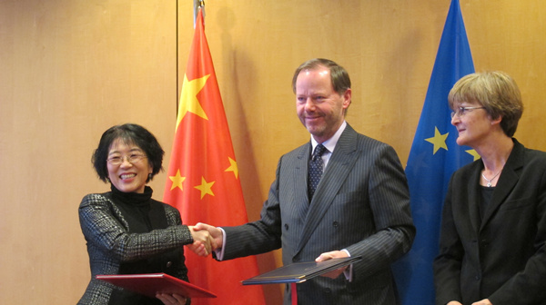 Chinese Ambassador to EU Yang Yanyi (left) signs an agreement with EU officials in Brussels on Monday to facilitate the visa-free move of diplomats on both sides. (Photo by Gao Shuang/China Daily)