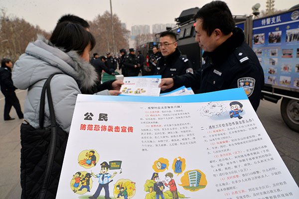 Police officers show passers-by how to react to terrorist attacks at a publicity event highlighting the Anti-Terrorism Law in Handan, Hebei province, in January. Hao Qunying / For China Daily
