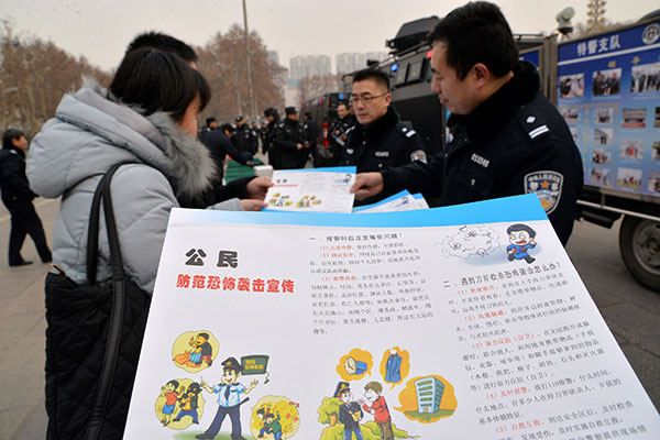 Police officers show passers-by how to react to terrorist attacks at a publicity event highlighting the Anti-Terrorism Law in Handan, Hebei province, in January. Hao Qunying / For China Daily