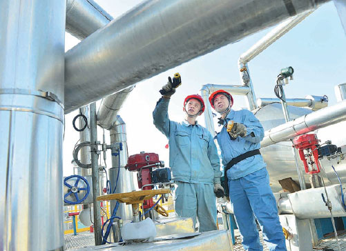 Technicians inspect a CO2 recycling project at a petrochemical plant belonging to Sinopec Group in Puyang, Henan province. Tong Jia / For China Daily
