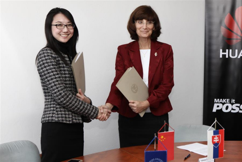 Liang Yan (L), General manager of Huawei Technologies(Slovak) and Rector of the Zilina University Tatiana Corejova shakes hands after signing the agreement of the cooperation in technology research in Zilina, Slovakia on March 2, 2016. 