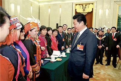 Chinese President Xi Jinping (front R), also general secretary of the Communist Party of China (CPC) Central Committee and chairman of the Central Military Commission, greets female deputies for the International Women's Day at a panel discussion with deputies to the 12th National People's Congress (NPC) from South China's Guangxi Zhuang autonomous region during the third session of the 12th NPC, in Beijing, March 8, 2015. (Photo/People's Daily Online)