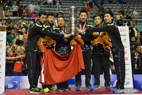 Members and Coach of China's men's table tennis team pose for photo with trophy after winning the final against Japan at the 2016 World Team Championships in Kuala Lumpur, Malaysia, March 6, 2016. China's men's table tennis team won 3-0 to claim their eighth straight men's title at the World Team Table Tennis Championships here on Sunday.(Photo: Xinhua/Chong Voon Chung)