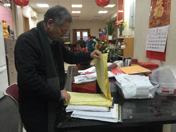 Eddie Chiu, director of Lin Sing Association, flipped through five large notepads filled with names and donation amounts made by the New York Chinese community to support Peter Liang's further legal fee for appeal. (Photo: China Daily/Heizi Jiang)