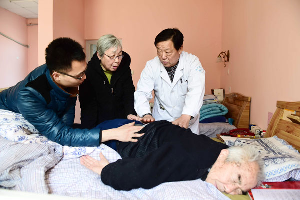 Doctor Wang Yunde from the Zhangqiu No 2 People's Hospital evaluates an elderly patient at a nursing home in Jinan, East China's Shandong province, on March 1, 2016. (Photo/Xinhua)