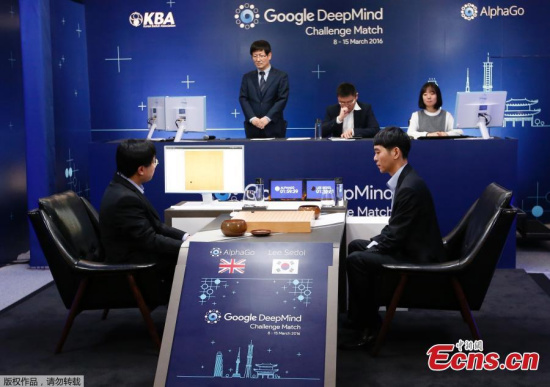 South Korean professional Go player Lee Sedol, right, puts a stone against Google's artificial intelligence program, AlphaGo, as Google DeepMind's lead programmer Aja Huang, left, sits during the match in Seoul on Wednesday.(Photo/Agencies)