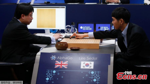 South Korean professional Go player Lee Sedol, right, puts a stone against Google's artificial intelligence program, AlphaGo, as Google DeepMind's lead programmer Aja Huang, left, sits during the match in Seoul on Wednesday.(Photo/Agencies)