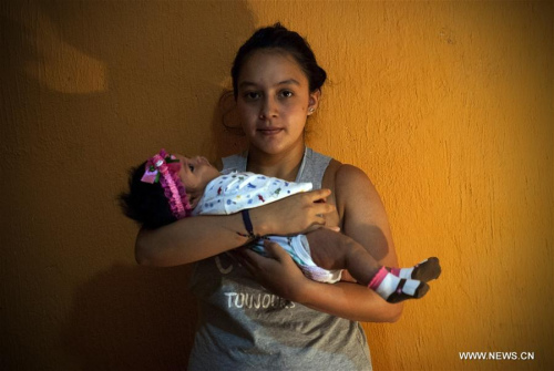 Image taken on Feb. 27, 2016 shows Angela Martinez (Back), holding her daughter Dominic Andrade, who suffers microcephaly, in Quito, capital of Ecuador. (Xinhua file photo/Santiago Armas)