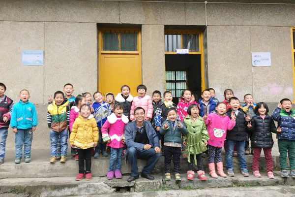 Ge Yike, one of the initiators for the charity projectOne School One Dream, with pupils of Shima primary school in Badong county, Central China's Hubei province, Oct 2015. (Photo provided to chinadaily.com.cn)