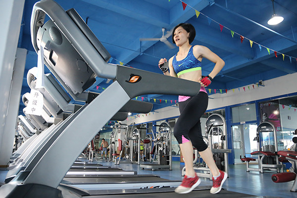 A women runs on a treadmill in Chenzhou, Hunan province. Going to gyms is now a popular workout option for the working class even beyond first-tier cities. (Photo/China Daily)