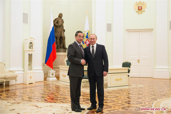 Russian President Vladimir Putin (R) shakes hands with visiting Chinese Foreign Minister Wang Yi during their meeting in Moscow, capital of Russia, on March 11, 2016. (Photo/Xinhua)