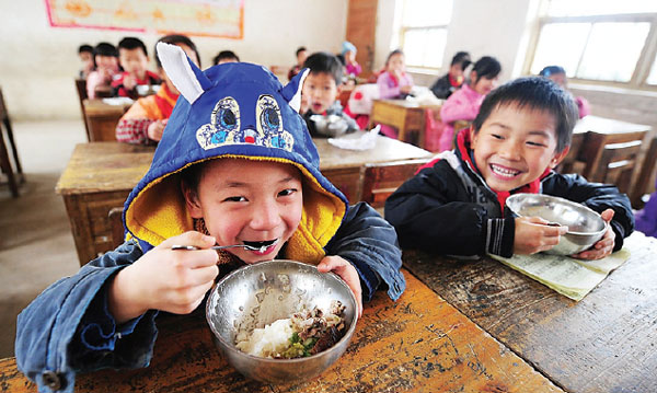 Students have free lunch at a classroom of a primary school in Mashan county, Guangxi Zhuang autonomous region. The Free Lunch for Children project has benefited 465 schools in poverty-stricken areas across China. Provided to China Daily