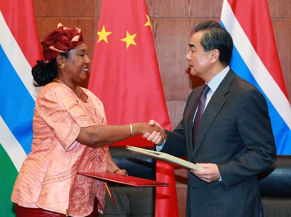 Foreign Minister Wang Yi greets his Gambian counterpart Neneh Macdouall-Gaye at a signing ceremony in Beijing on Thursday. ZOU HONG / CHINA DAILY
