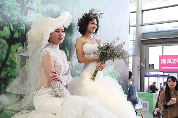 Two models in gowns greet visitors during the 17th Xi'an Spring Wedding Expo. The event took place in Xi'an, Shaanxi province, on March 12 and 13. (Photo provided to China Daily)