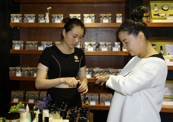 A customer tries a natural essential oil product at a store franchised by Herb-tale, a producer of skin care products in Kunming, the capital of Yunnan. (Photo provided to China Daily)