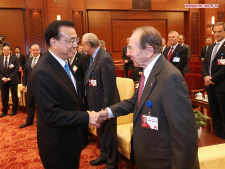 Chinese Premier Li Keqiang (L) shakes hands with Maurice R. Greenberg during a meeting with overseas delegates attending the China Development Forum in Beijing, capital of China, March 21, 2016. (Xinhua/Pang Xinglei)