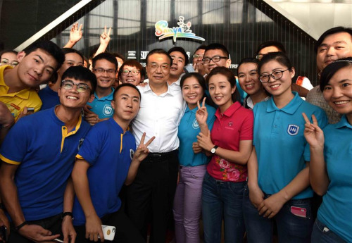 Chinese Premier Li Keqiang (3rd L, front) poses for photos with people at Sanya Resident & Visitor Information Center in Sanya, south China's Hainan Province, March 22, 2016. Li had an inspection tour in Sanya and Qionghai of Hainan Province from March 22 to 25, during which Li presided over the 1st Lancang-Mekong Cooperation Leaders' Meeting and attended the Boao Forum for Asia (BFA) annual conference 2016. (Xinhua/Rao Aimin)