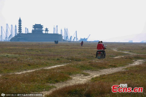 An island stands in Poyang Lake after water level declines in Xingzi county, Jiujiang city, East China��s Jiangxi province, Jan 3, 2015. Due to persistent drought and less runoff from the upstream, the county��s landmark is now accessible by walking, rather than a boat during the wet season. (Photo/CFP)