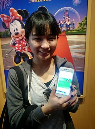 A tourist from Taiwan province displays her e-ticket for the Shanghai Disney Resort on Monday. (Photo/Xinhua)