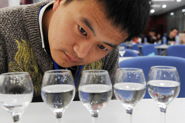A man examines baijiu during a liquor-tasting contest in Bozhou, Anhui province. (Photo/China Daily)