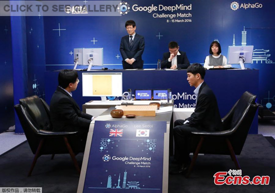 South Korean professional Go player Lee Sedol, right, puts a stone against Google's artificial intelligence program, AlphaGo, as Google DeepMind's lead programmer Aja Huang, left, sits during the match in Seoul on Wednesday.(Photo/Agencies)