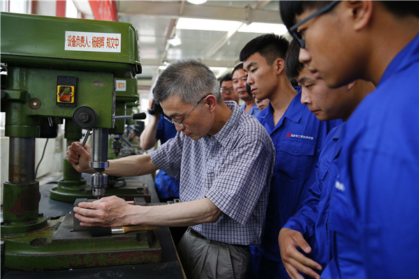 Hu Shuangqian teaches students at Beijing Industry and Trade Technicians College, in Beijing, May 28, 2015. (Photo/Xinhua)
