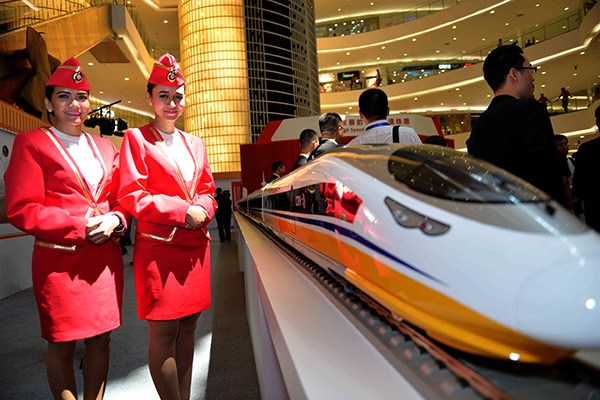 Two women stand by the model of a bullet train manufactured by China Railway Rolling Stock Corp at a fair in Jakarta, Indonesia. (Photo/Xinhua)