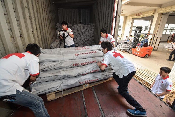 Staff members of the Red Cross Society of China load relief materials onto a vehicle on April 27, 2015. The relief materials were delivered to earthquake-stricken Nepal. (Photo/Xinhua)