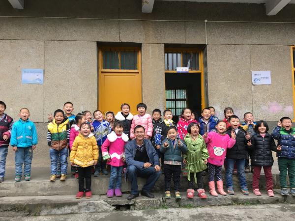 Ge Yike, one of the initiators for the charity project "One School One Dream", with pupils of Shima primary school in Badong county, Central China's Hubei province, Oct 2015. (Photo provided to chinadaily.com.cn)