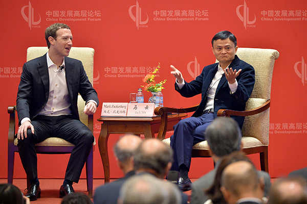 Mark Zuckerberg, CEO of Facebook Inc, talks with Jack Ma, chairman of Alibaba Group Holding Ltd at the China Development Forum in Beijing on Saturday. (Photo/Xinhua)