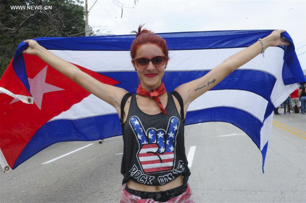 A woman poses with the Cuban national flag near the Sports City ahead of the free concert of British band The Rolling Stones, in Havana, Cuba, on March 25, 2016. (Xinhua/Paula Ribas/TELAM)