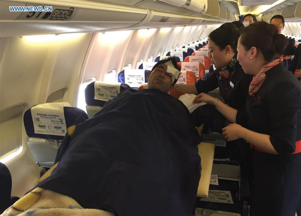 A Chinese wounded is transfered on an airplane back to China in Vientiane, Laos, on March 25, 2016. Six Chinese nationals were wounded in an attack on a cross-border passenger bus in northern Laos Wednesday night, the Chinese embassy said. (Xinhua/Ren Baoguo)