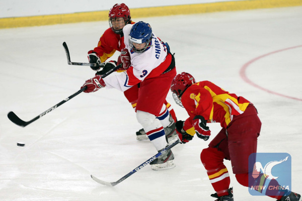 Zhang Mengying (L) and Liu Zhixin (R) of China vie with Klara Chmelova of the Czech Republic during a final stage match of the women's ice hockey qualification tournament of 2014 Winter Olympics, in Weiden, Germany, on Feb. 10, 2013. (Xinhua/Luo Huanhuan)