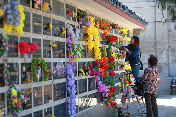 People use fresh flowers to commemorate their deceased family members at Beijing's Babaoshan Cemetry on Sunday, ahead of Tomb Sweeping Day, which falls on Monday. ZOU HONG/CHINA DAILY