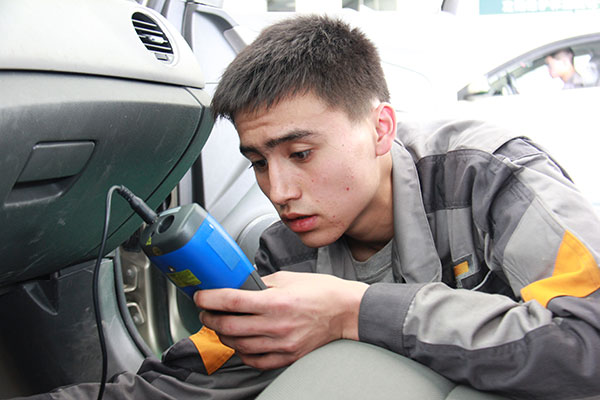 Arfanjan Osmanjan troubleshoots a car's air conditioning unit at Anhui Automobile Industry School. Zhu Lixin / China Daily
