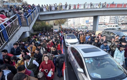 Candidates walk out after taking the civil servant exam in Hefei, capital of east China's Anhui Province, Nov. 29, 2015. (Photo: Xinhua/Zhang Duan)