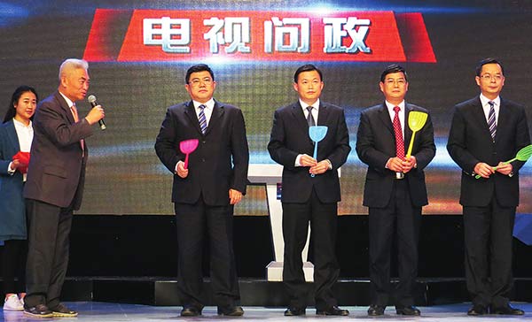 Officials of four counties in the Guangxi Zhuang autonomous region show the fly swatters they received as gifts from the audience during a TV series on March 27. Provided to China Daily