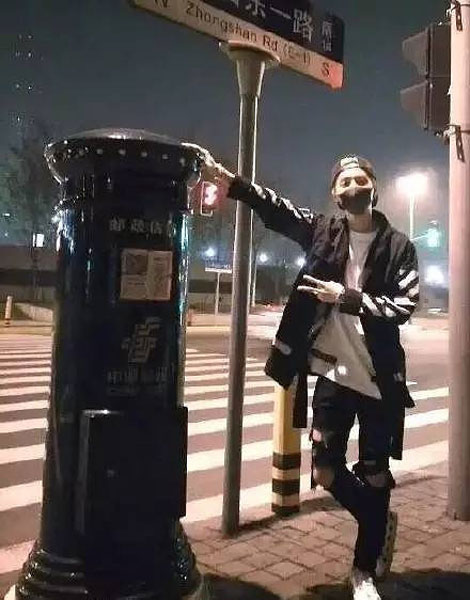 An undated photo shows Chinese music star Lu Han poses for photos next to a postbox in Shanghai. (Photo/yangtse.com)
