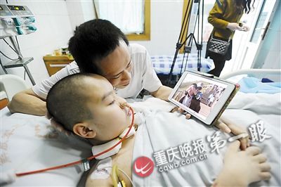 Cheng Jun shows Ruirui photos of happy past events on a tablet PC. (Photo/Chongqing Evening News)