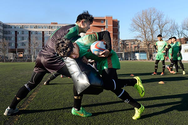 Two university students in Beijing take part in rugby training. WEI XIAOHAO / FOR CHINA DAILY