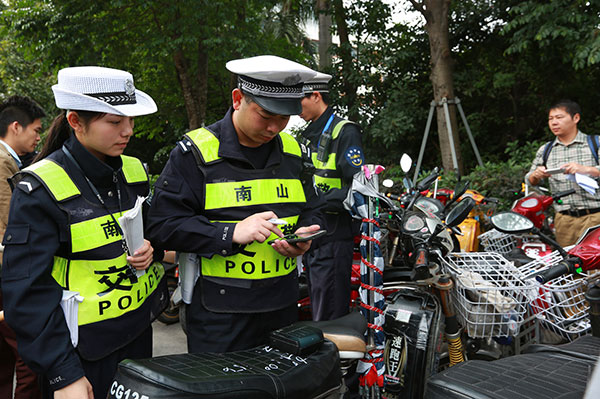 Traffic police officers in Shenzhen, Guangdong province, seize unlicensed electric bikes and freight tricycles in March. (XUAN HUI/CHINA DAILY)