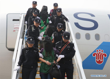 Chinese telecom fraud suspects deported from Kenya get off a plane after arriving at the Beijing Capital International Airport in Beijing, capital of China, April 13, 2016. (Photo: Xinhua/Yin Gang)